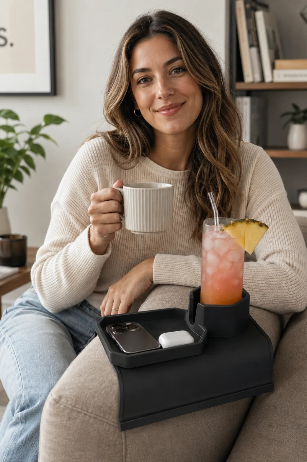 Person relaxing on a couch with a drink resting in the Sofa Sidekick